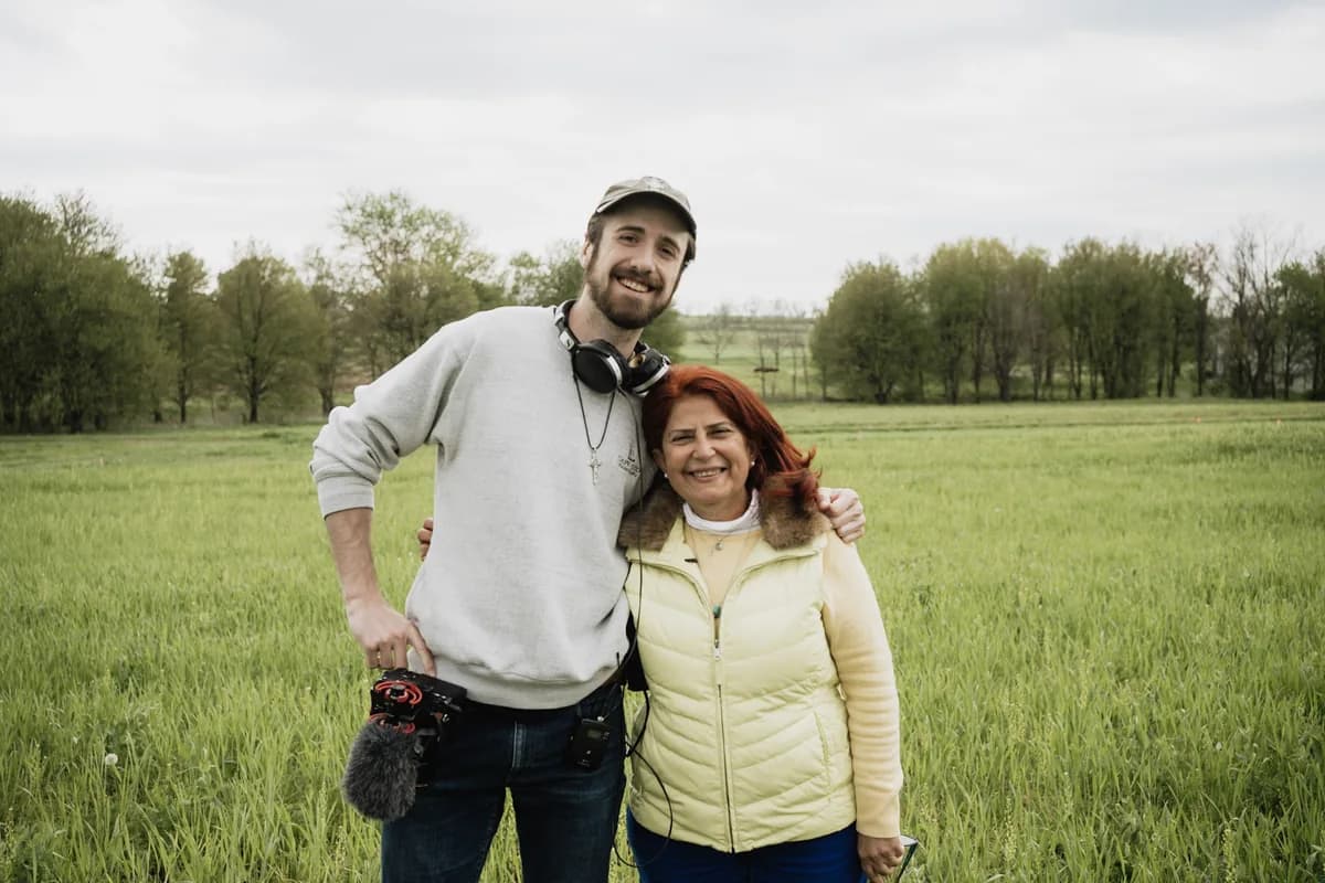Jack Dempsey with a customer in a green pasture during a farm visit