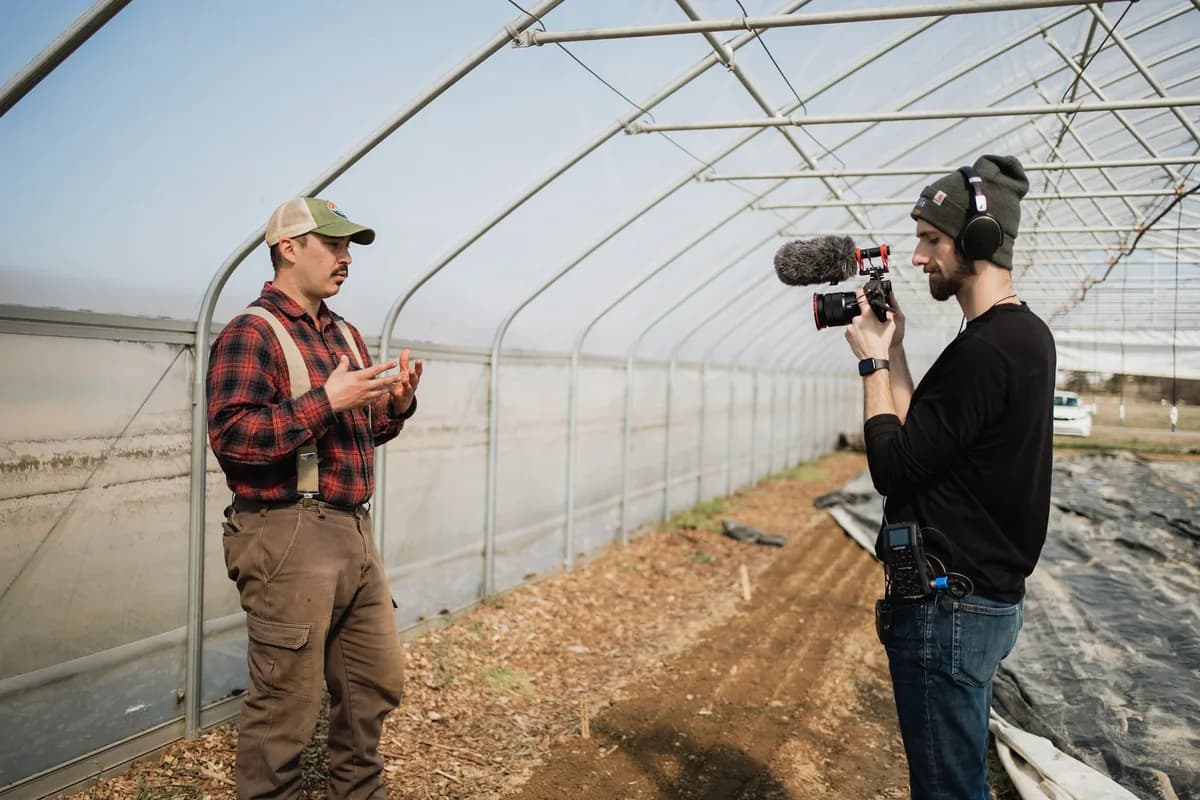 A farm conversation being filmed inside a greenhouse
